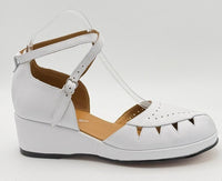 A white vintage wedge sandal with cutout details and an ankle strap.