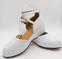 A pair of white leather vintage wedge sandals with wrap-around ankle straps.