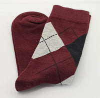 A folded pair of burgundy argyle socks with white and black details.