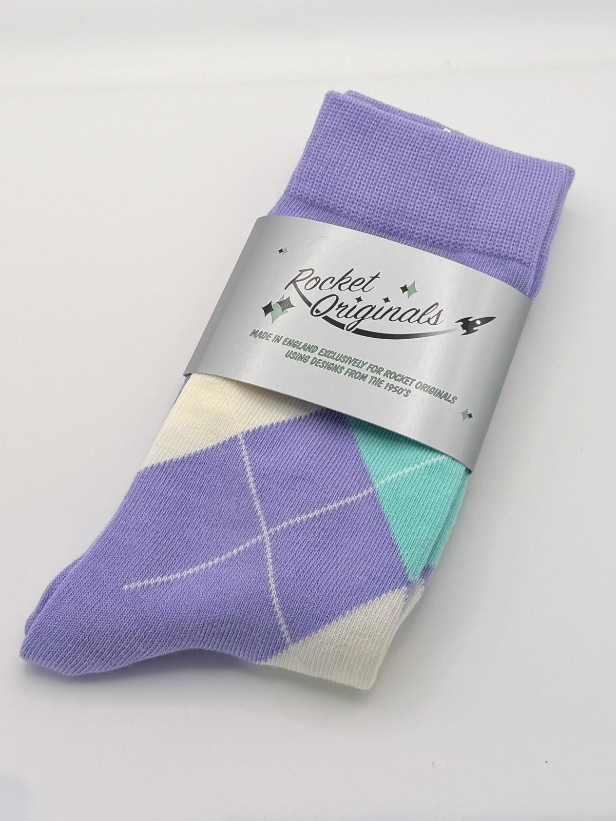 A single folded sock with a purple and mint argyle pattern and a silver paper band.